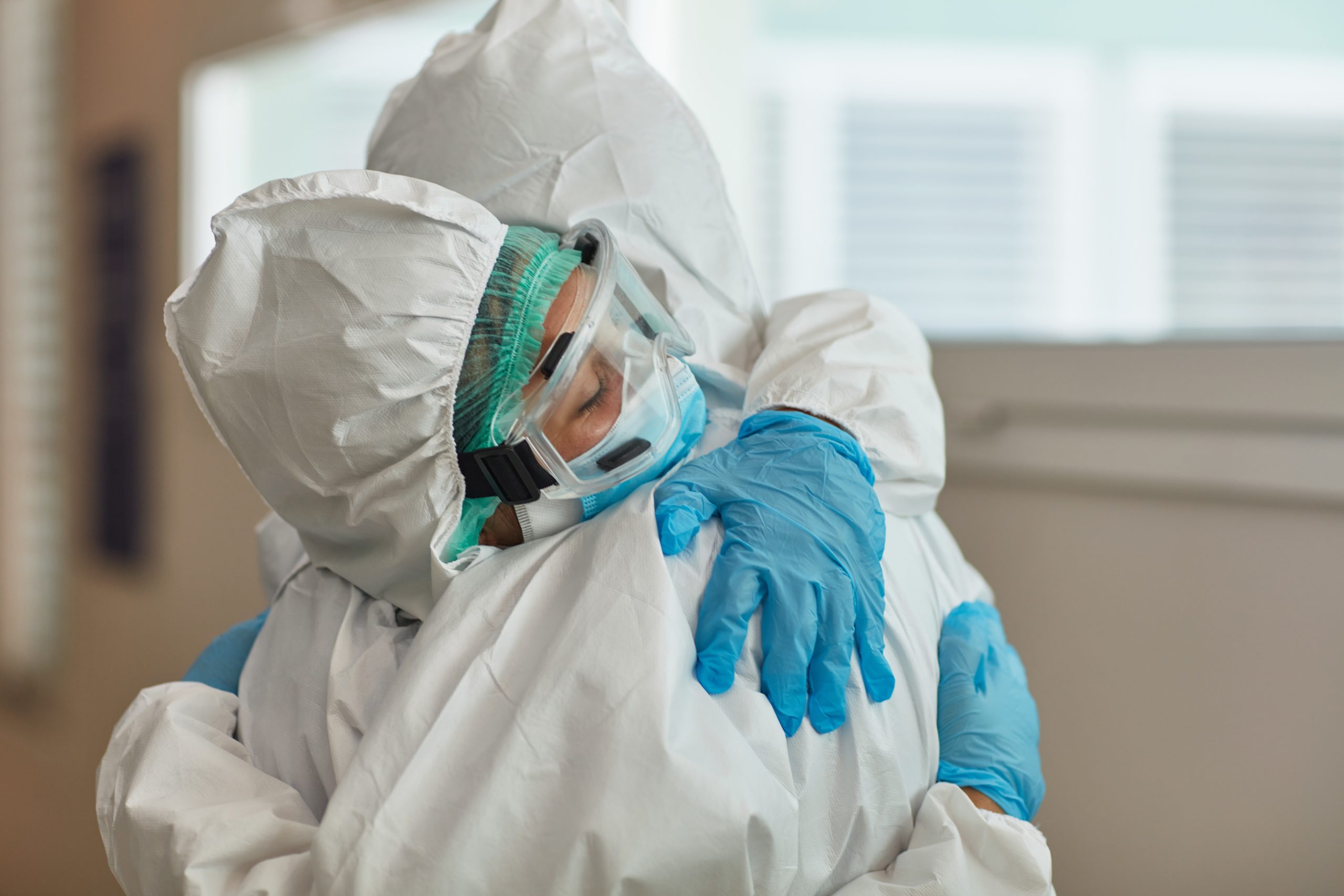 Medical Team in Protective Workwear Embracing in Support